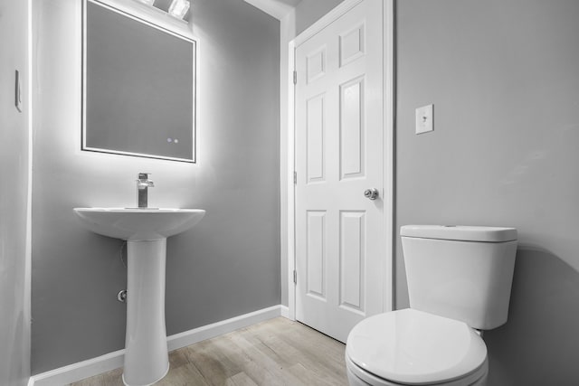 bathroom with hardwood / wood-style flooring and toilet