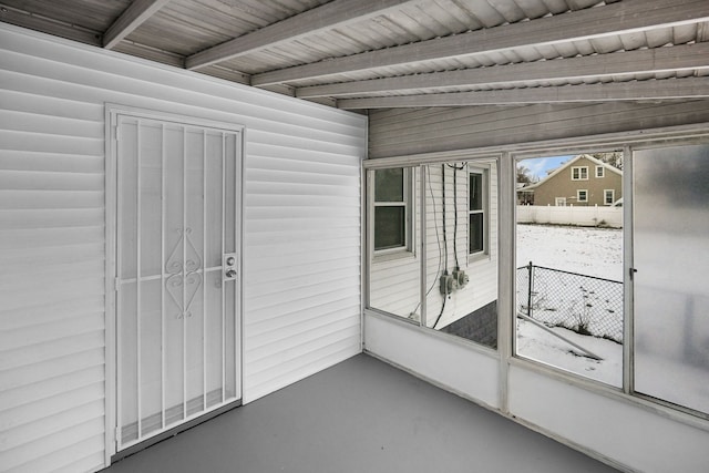 unfurnished sunroom with beamed ceiling