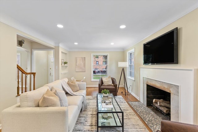 living room featuring wood-type flooring and crown molding