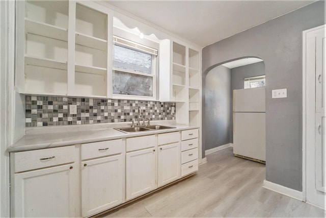 kitchen with white refrigerator, light hardwood / wood-style flooring, a wealth of natural light, and sink