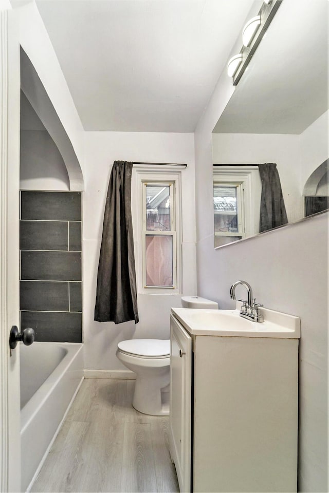 bathroom with wood-type flooring, vanity, and toilet