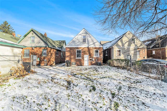 snow covered house with central AC