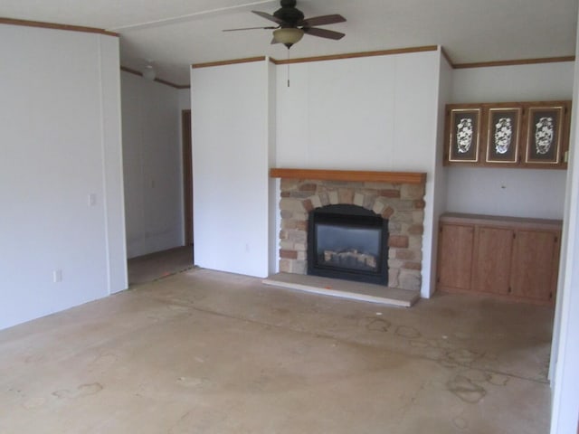 unfurnished living room with a stone fireplace, ceiling fan, and ornamental molding