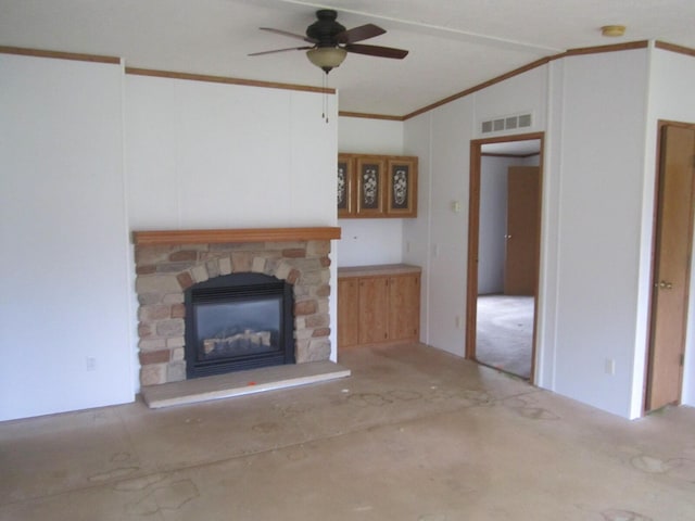 unfurnished living room with crown molding, ceiling fan, lofted ceiling, and a stone fireplace