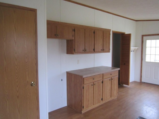 kitchen featuring light hardwood / wood-style floors and crown molding