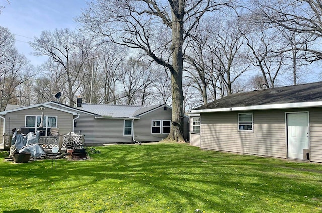 rear view of property featuring a lawn