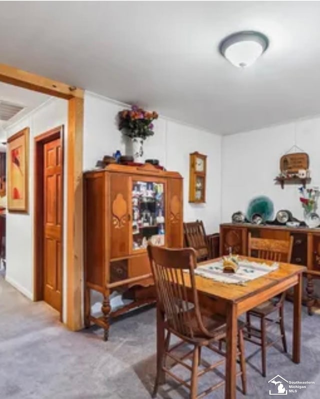 carpeted dining area with crown molding