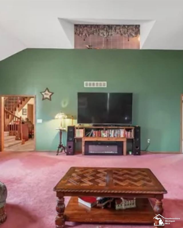 carpeted living room featuring vaulted ceiling