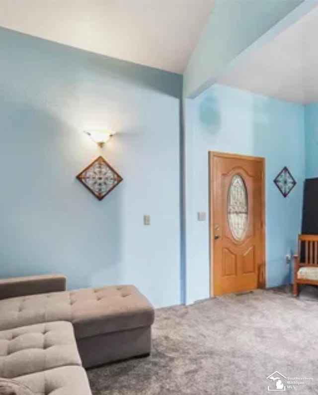 carpeted living room with vaulted ceiling