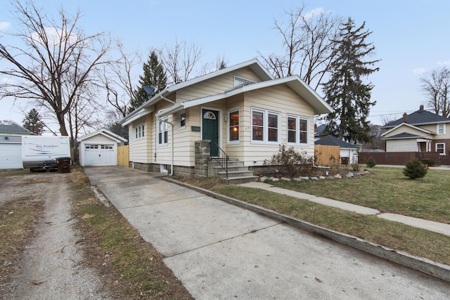 bungalow-style home featuring a garage, a front lawn, and an outdoor structure