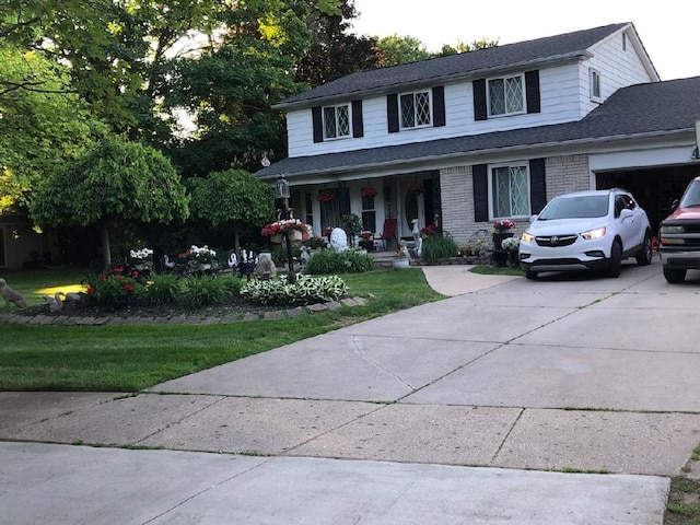 view of front facade featuring a porch, a garage, and a front yard
