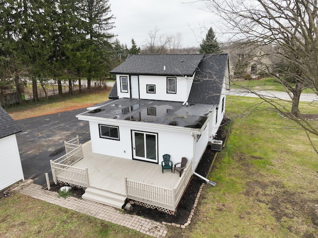rear view of house featuring a yard and a wooden deck