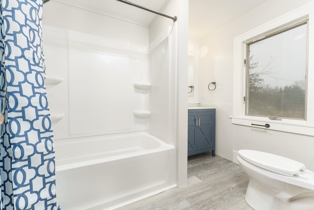 full bathroom featuring hardwood / wood-style floors, vanity, toilet, and shower / bathtub combination with curtain