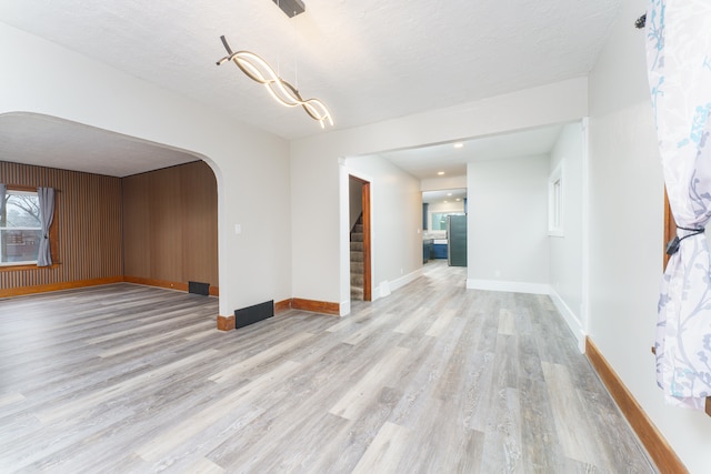 empty room with a textured ceiling and light wood-type flooring