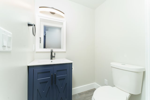 bathroom with wood-type flooring, vanity, and toilet