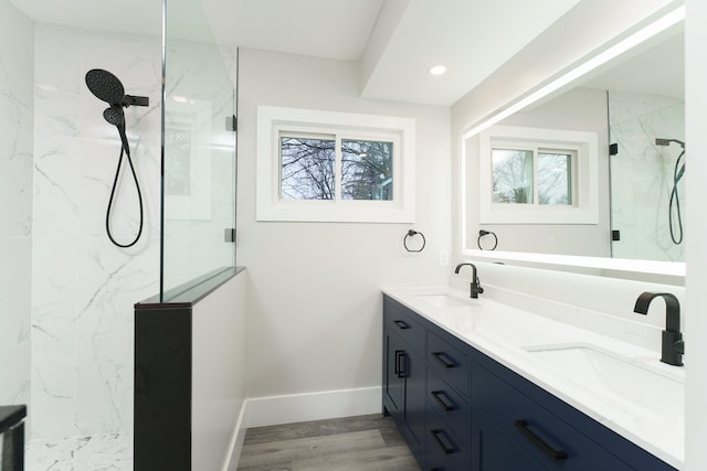 bathroom with a tile shower, hardwood / wood-style floors, and vanity