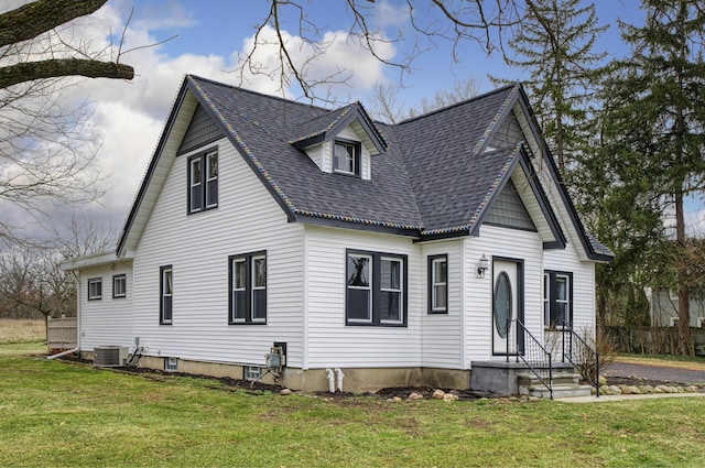 cape cod-style house featuring cooling unit and a front lawn