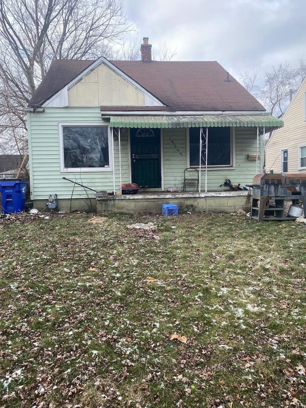 bungalow featuring covered porch and a front yard