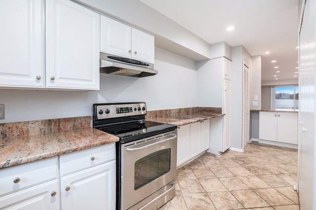 kitchen featuring stainless steel electric stove, white cabinets, light tile patterned floors, and light stone counters