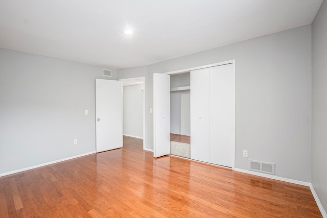 unfurnished bedroom featuring hardwood / wood-style floors and a closet