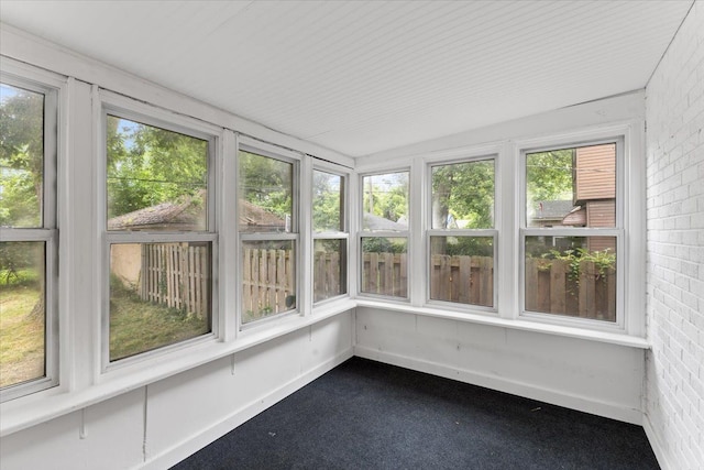 unfurnished sunroom featuring vaulted ceiling and plenty of natural light