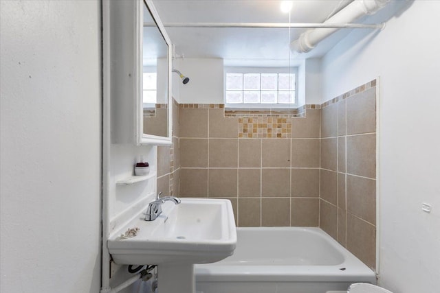 bathroom featuring tiled shower / bath and sink