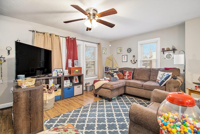 living room with ceiling fan, wood-type flooring, a textured ceiling, and a wealth of natural light