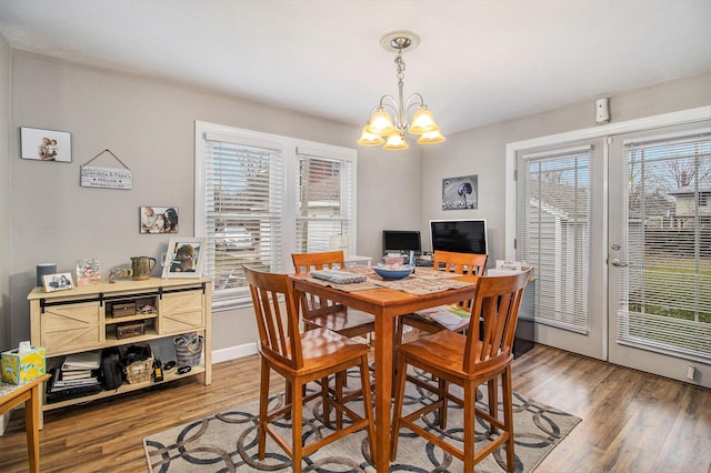 dining space featuring hardwood / wood-style floors and a notable chandelier