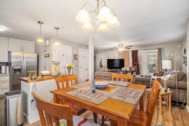 dining room featuring ceiling fan with notable chandelier and light wood-type flooring