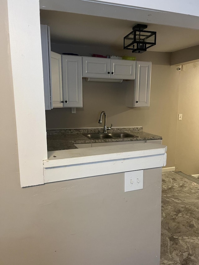 kitchen featuring white cabinetry and sink