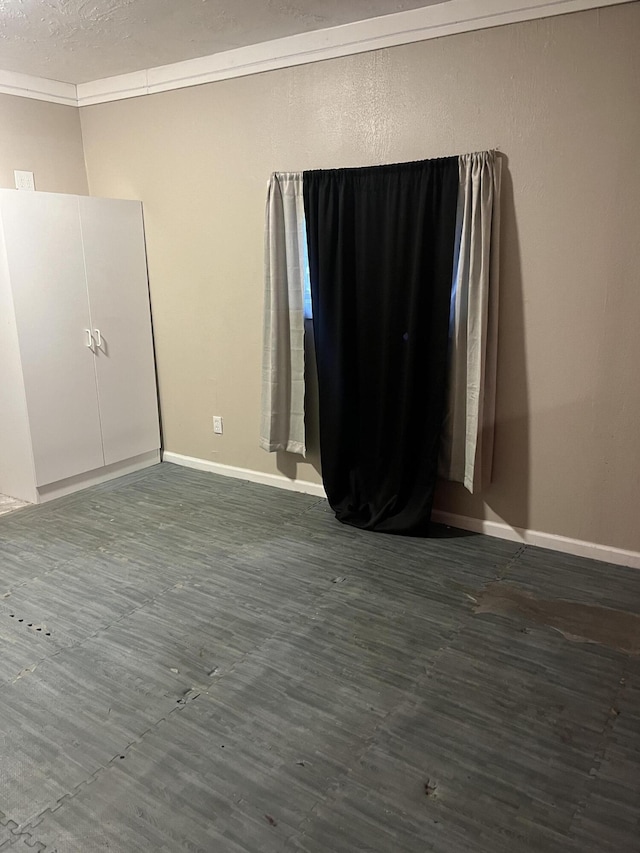 empty room featuring a textured ceiling and crown molding