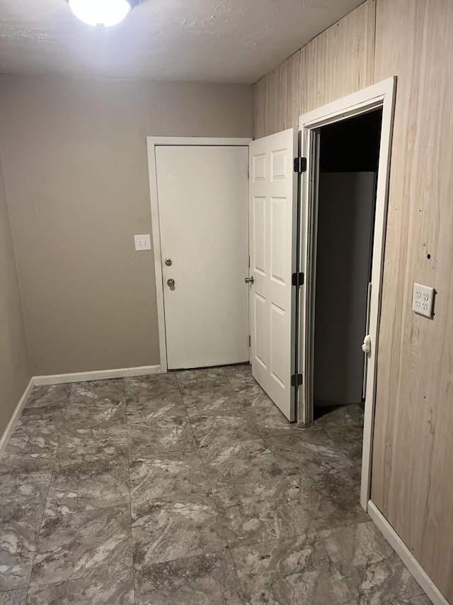 hallway featuring wood walls