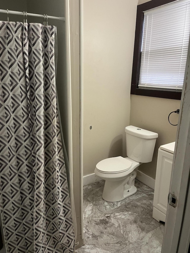 bathroom featuring vanity, toilet, and curtained shower