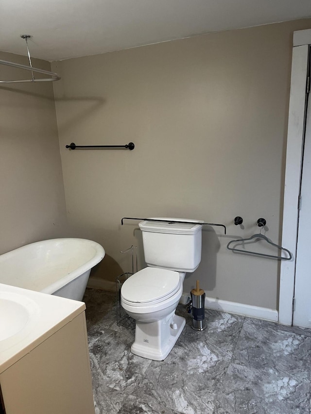 bathroom with a bathing tub, vanity, and toilet