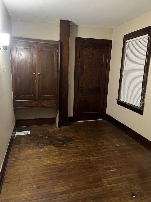 interior space with dark wood-style flooring and baseboards