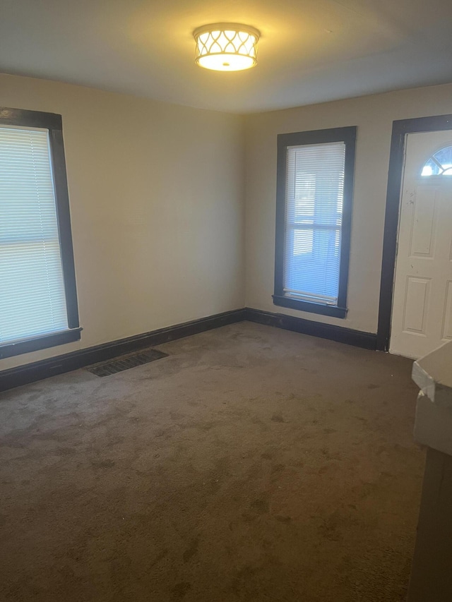 carpeted foyer entrance with visible vents and baseboards