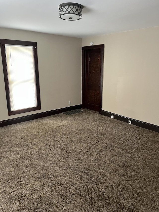 unfurnished room with baseboards and carpet flooring