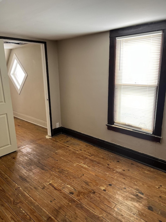 empty room with dark wood-type flooring and baseboards