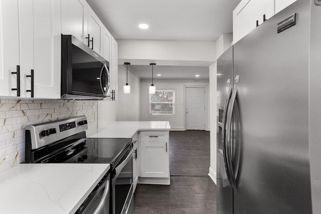 kitchen with white cabinetry, dark wood-type flooring, stainless steel appliances, light stone counters, and decorative light fixtures