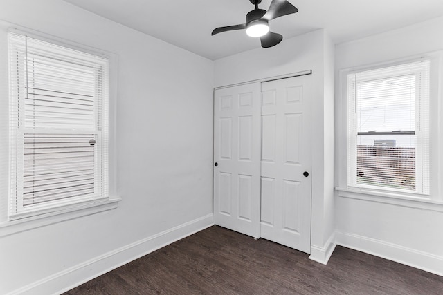 unfurnished bedroom with ceiling fan, dark hardwood / wood-style flooring, and a closet