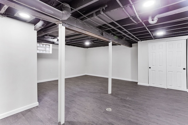 basement with dark hardwood / wood-style floors