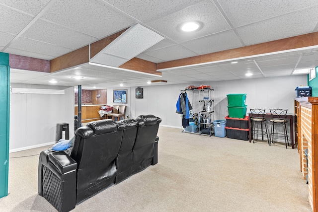 carpeted home theater room with a drop ceiling