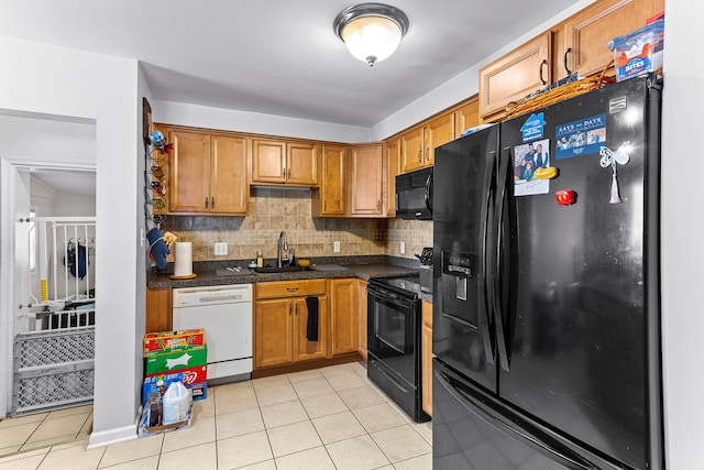 kitchen featuring light tile patterned flooring, sink, black appliances, and tasteful backsplash