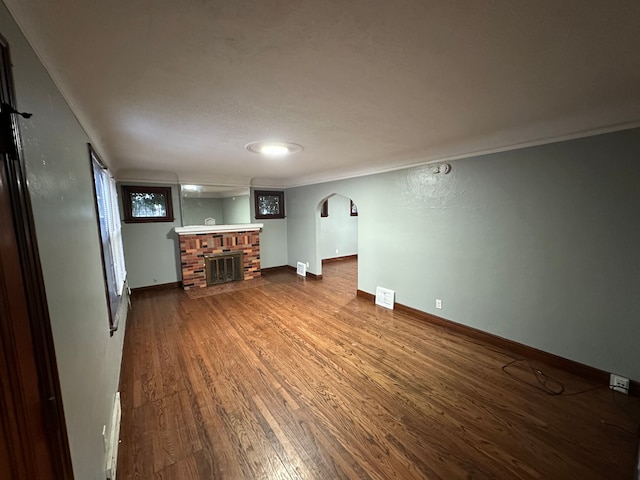 unfurnished living room with a fireplace, wood-type flooring, and a baseboard radiator