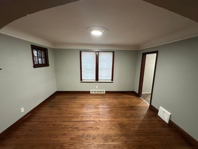 unfurnished room featuring dark hardwood / wood-style flooring and crown molding