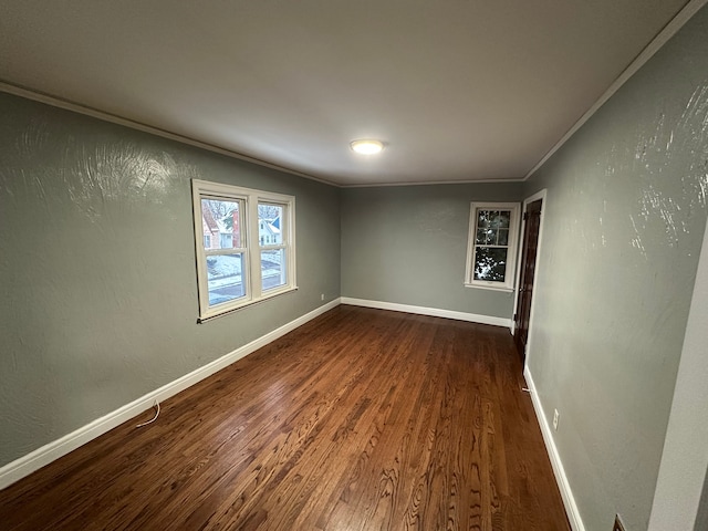 spare room featuring dark hardwood / wood-style flooring and ornamental molding