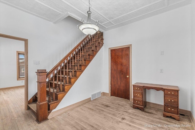 staircase featuring wood-type flooring and a textured ceiling