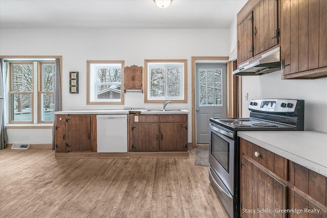 kitchen featuring white dishwasher, light hardwood / wood-style floors, stainless steel electric range oven, and sink