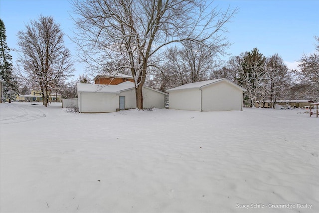 yard covered in snow featuring an outbuilding