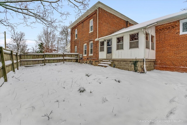 view of snow covered rear of property